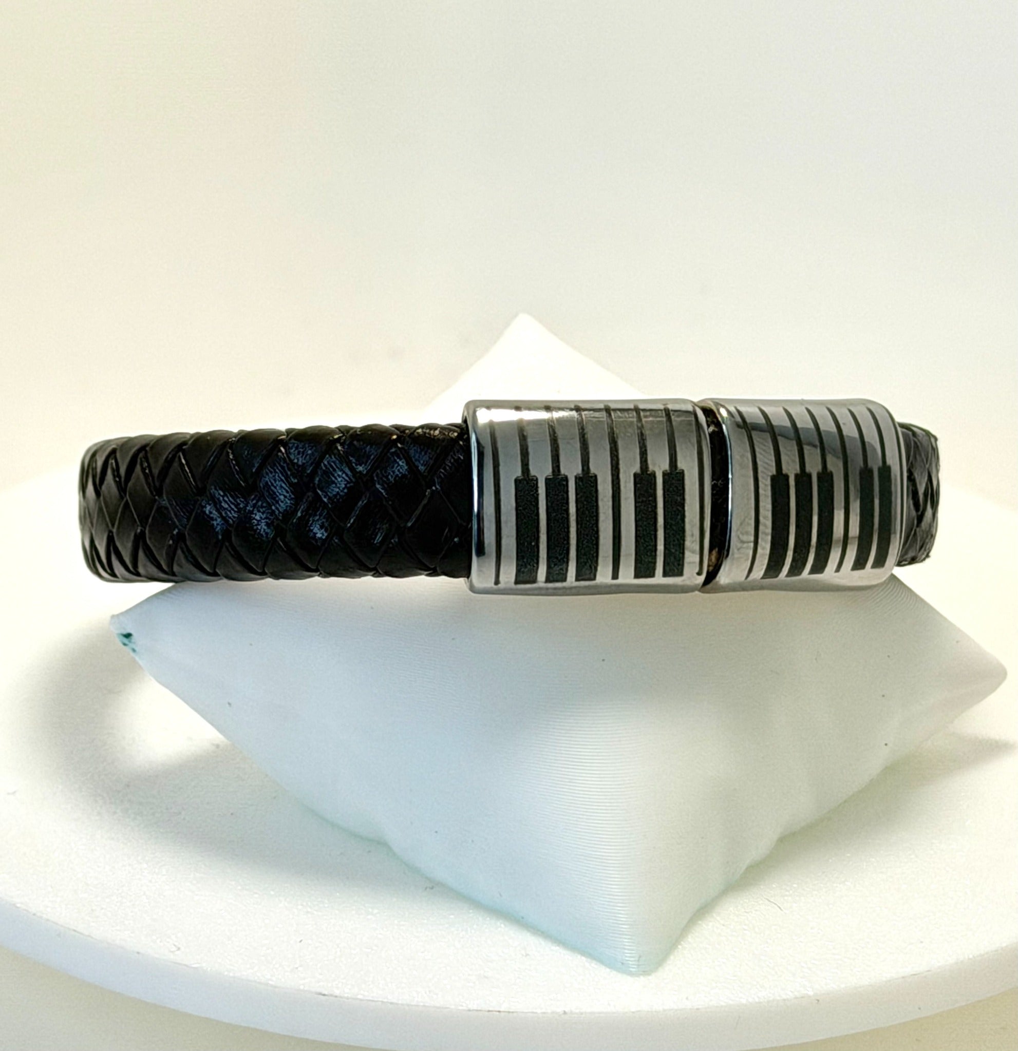 Pianoarmband i svart flätat läder med graverad ståldetalj